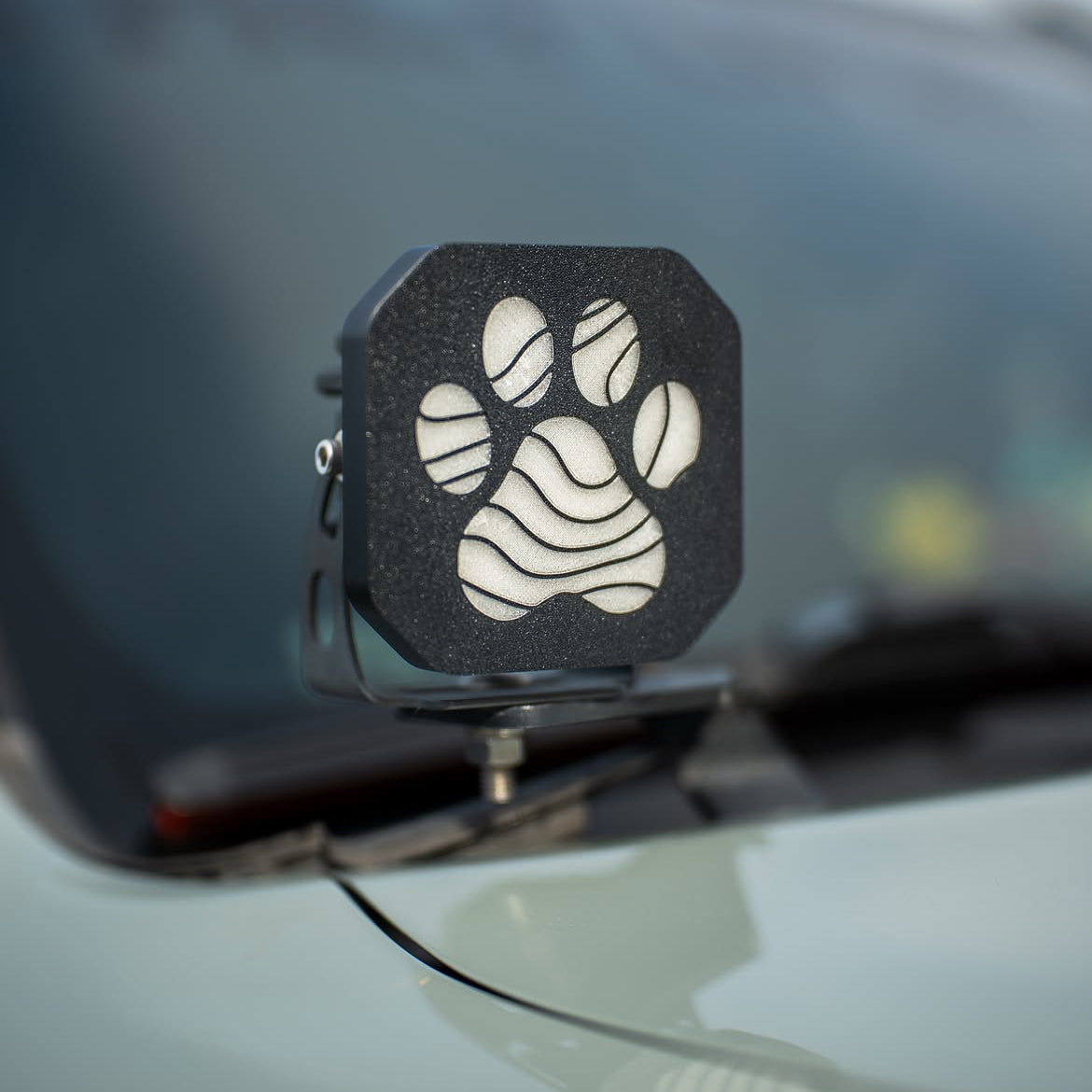 Custom paw print cover on a Diode Dynamics pod light mounted on a white truck