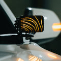 Topography cover glowing amber on a Diode Dynamics pod light by a truck mirror