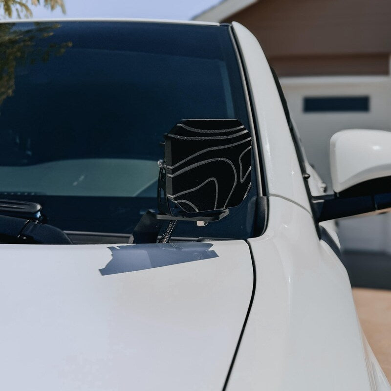 Topography cover on a Diode Dynamics SS3 pod light by the windshield of a white truck